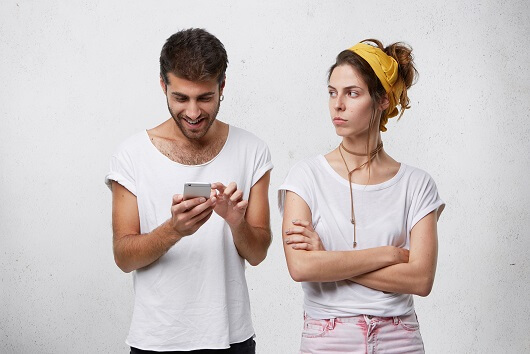 Angry girl keeping arms crossed and looking at her fake friend