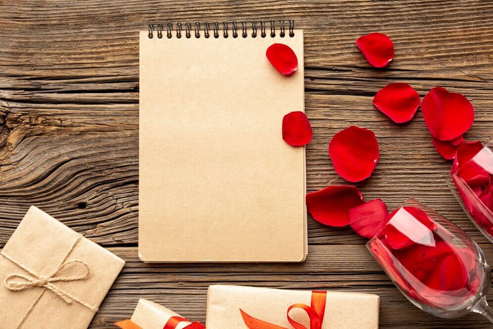 Valentines day composition with empty notepad and petals